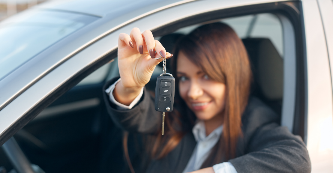Business professional holding car keys inside a vehicle, representing monthly car rental in San Francisco