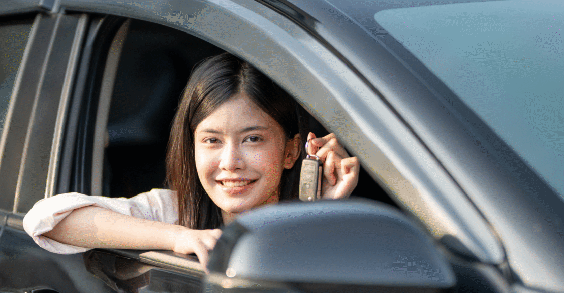 Woman holding car keys while sitting in a rental car, illustrating a monthly car rental guide in San Jose with cost-saving tips
