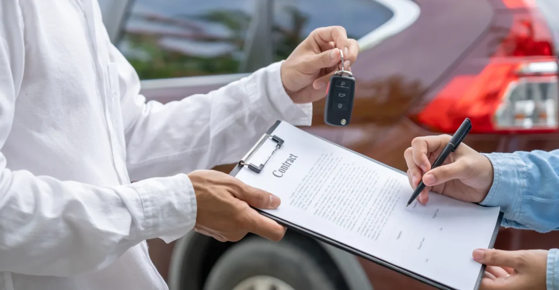Business traveler completing a vehicle agreement, representing professional corporate transportation services for executive and business travel.
