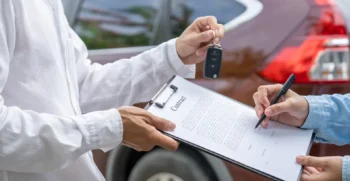 Business traveler completing a vehicle agreement, representing professional corporate transportation services for executive and business travel.